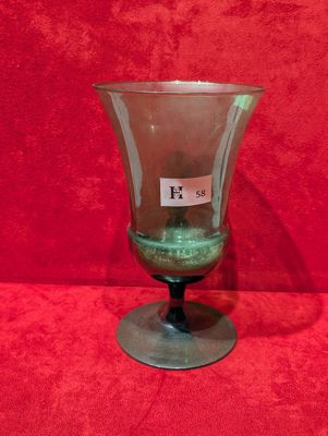 une image représentant un vase en verre posé sur une surface rouge
