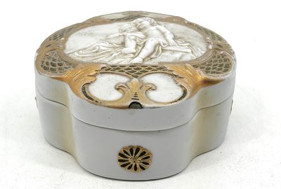 une boîte blanche et dorée sur laquelle figure l'image d'une femme