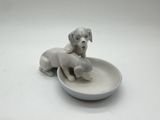 porcelain figurine of two dogs in a bowl on a white surface