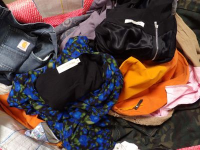 une pile de vêtements posée sur un lit