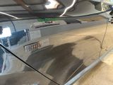 a car that has been painted silver in a garage