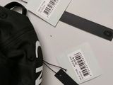 a black backpack with a tag on it and a pair of scissors
