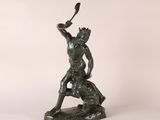 a bronze statue of a man holding a knife in his hand