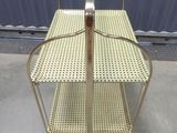 two tiered metal shelf with a basket on top of it