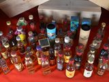 many bottles of alcohol on a table with a red cloth