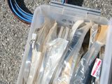 un récipient en plastique posé par terre et rempli de divers objets