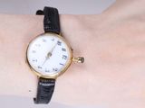 a woman ' s wrist that has a watch on it