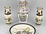 three vases, a plate and a bowl on a table