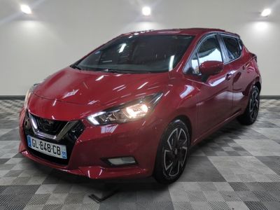 a red car is parked on a checkered floor in a garage