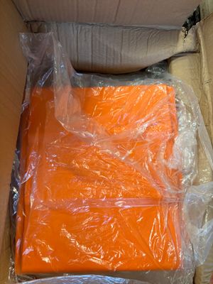 a box of orange shirts that are wrapped in plastic