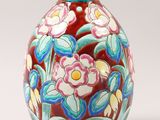 a vase with flowers painted on it sitting on a table