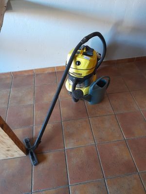 un aspirateur jaune et noir posé par terre près d'une fenêtre