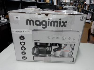 une machine à café emballée posée sur une table blanche dans un magasin