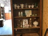 a wooden bookcase with many different items on it