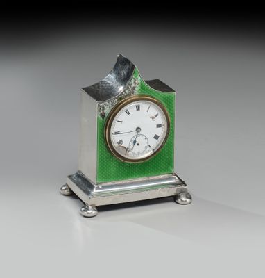 une petite horloge verte surmontée d'un oiseau