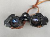 an old pair of binoculars sitting on top of a white surface