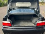 a black car with its trunk open in the parking lot