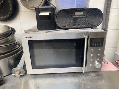un micro-ondes posé sur un plan de travail, à côté d'un mixeur