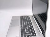 a silver laptop computer sitting on a white surface