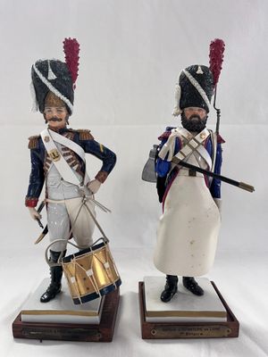 two figurines of soldiers with drums and drums on wooden bases