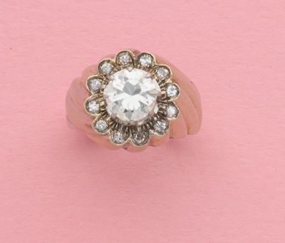 une image représentant une bague en diamant posée sur un fond rose