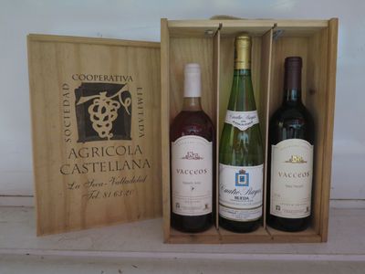 trois bouteilles de vin dans un coffret en bois sur une table