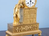 une horloge en or posée sur une table en bois
