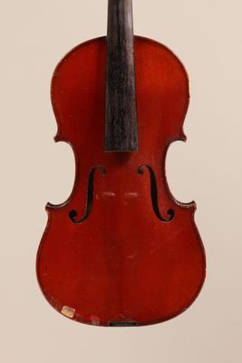 an old violin sitting on top of a white surface
