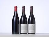 three bottles of red wine sitting on top of a table