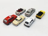 several toy cars are lined up in a row on a white surface