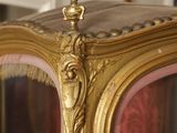 a gold and pink display case with a clock on it