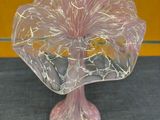 un vase en verre orné d'une fleur rose, posé sur une table
