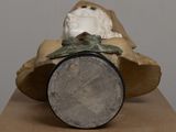 a statue of a man in a shell with a coin in it