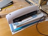 une agrafeuse posée sur une pile de papiers, sur un bureau