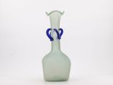 a glass vase with a blue handle sitting on a white surface
