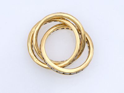 une image d'un gros plan d'une bague en or sur une surface blanche
