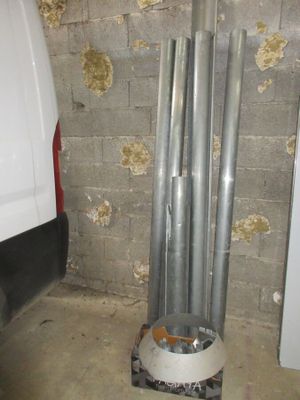 une camionnette blanche garée dans un garage, à côté d'un tas de tuyaux