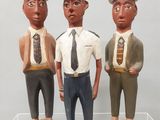 trois figurines représentant trois hommes portant un chapeau et une cravate