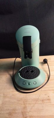 une cafetière verte posée sur une table en bois