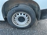une camionnette blanche qui a un pneu crevé