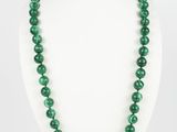 un collier de perles vertes sur un mannequin blanc