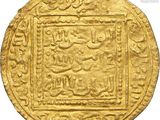 a close up of a gold coin with arabic writing on it