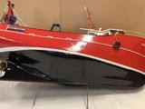 a red and black boat sitting on a white table