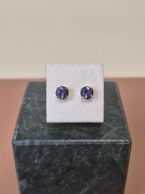a pair of blue sapphire earrings sitting on top of a marble block