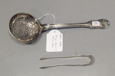 une cuillère en argent avec une étiquette et une paire de pinces