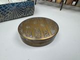 a small metal box sitting on a table next to a basket