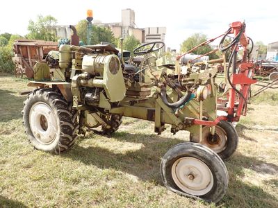un tracteur vert garé dans l'herbe