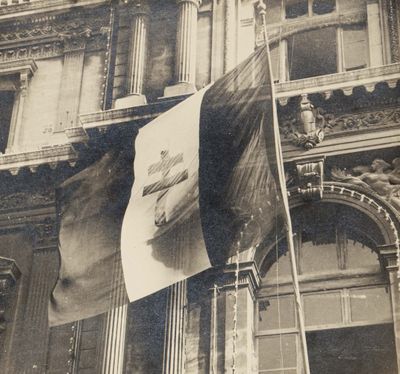 an old black and white photo of a flag flying in front of a building