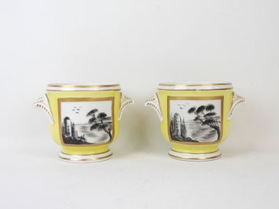 pair of yellow and white vases with a landscape painted on them