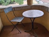 deux chaises et une table sur le balcon d'une maison